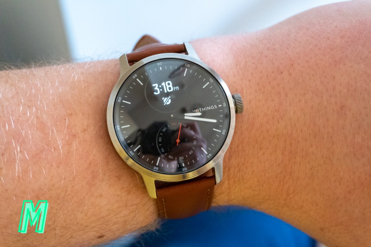 The 42mm Withings ScanWatch with its display lit up, sitting on a man's wrist.